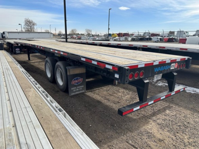 Trailer showing a flatbed trailer with multiple axles and Wabash branding at the rear.