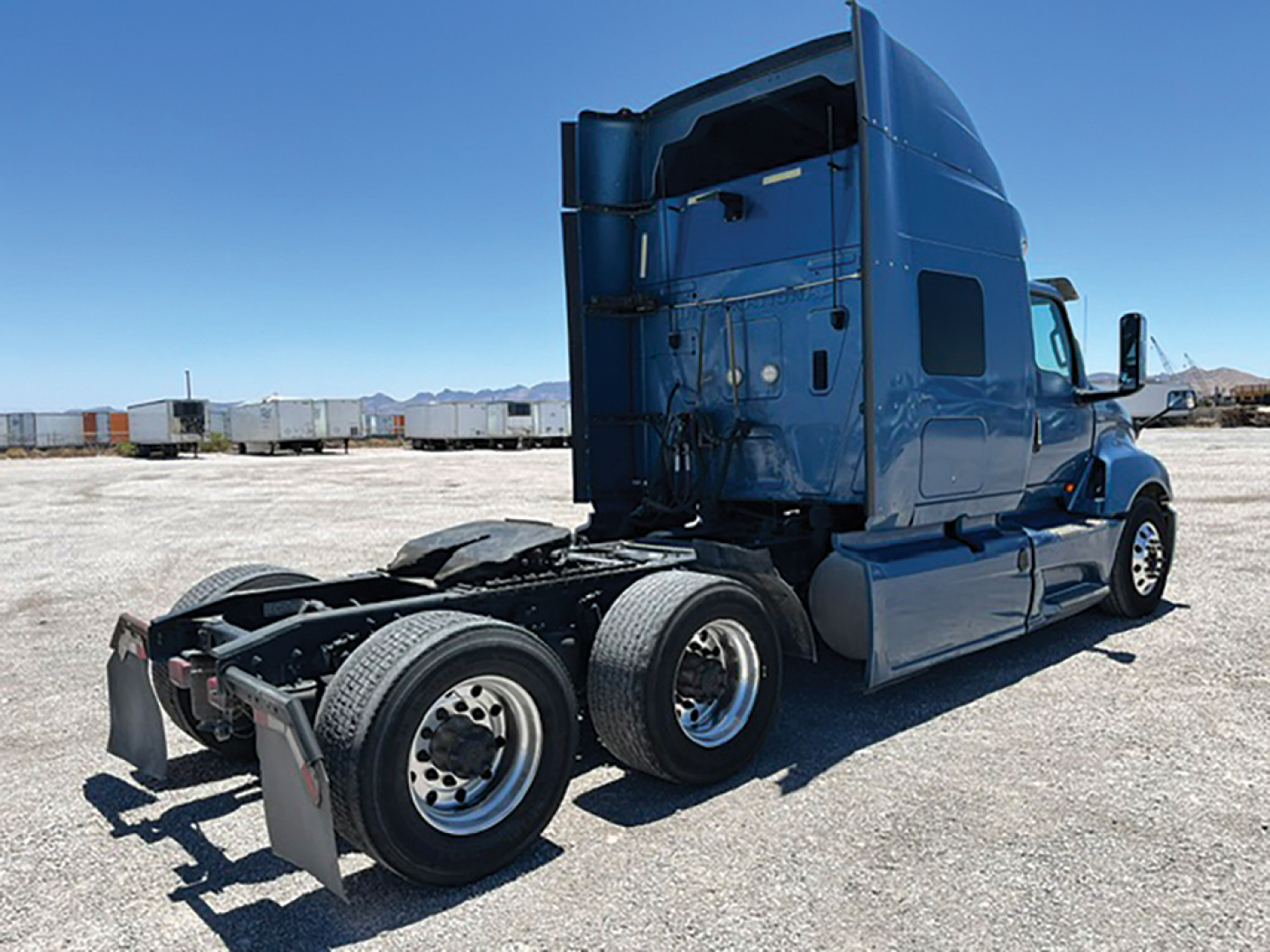 Truck cab and dual rear axles of a 2019 International LT625 tractor, side view, blue paint, visible sleeper cab, no trailer attached