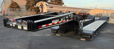 Load King 554-Quad-9'Wide-24"LDH trailer viewed from side, lowboy with extendable gooseneck and multiple wheels, reflective tape, and labeled components.