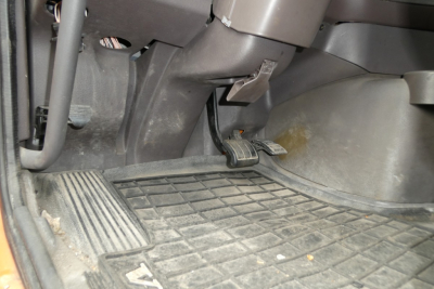 Interior floor area of a Volvo VNM cab showing pedals and driver-side floor mat.