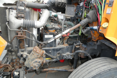 View of engine bay from left side showing various hoses, wiring, and components in a Volvo VNM42T conventional daycab truck.