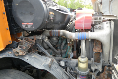 Volvo VNM42T engine bay showing air intake, coolant reservoir, hoses, and exposed engine components.