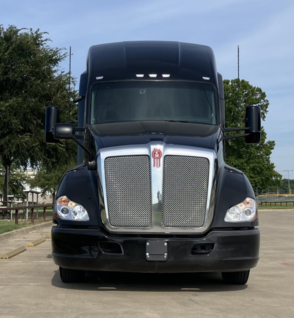 Front view of a 2022 Kenworth T680 conventional sleeper truck showing chrome grille and headlights.