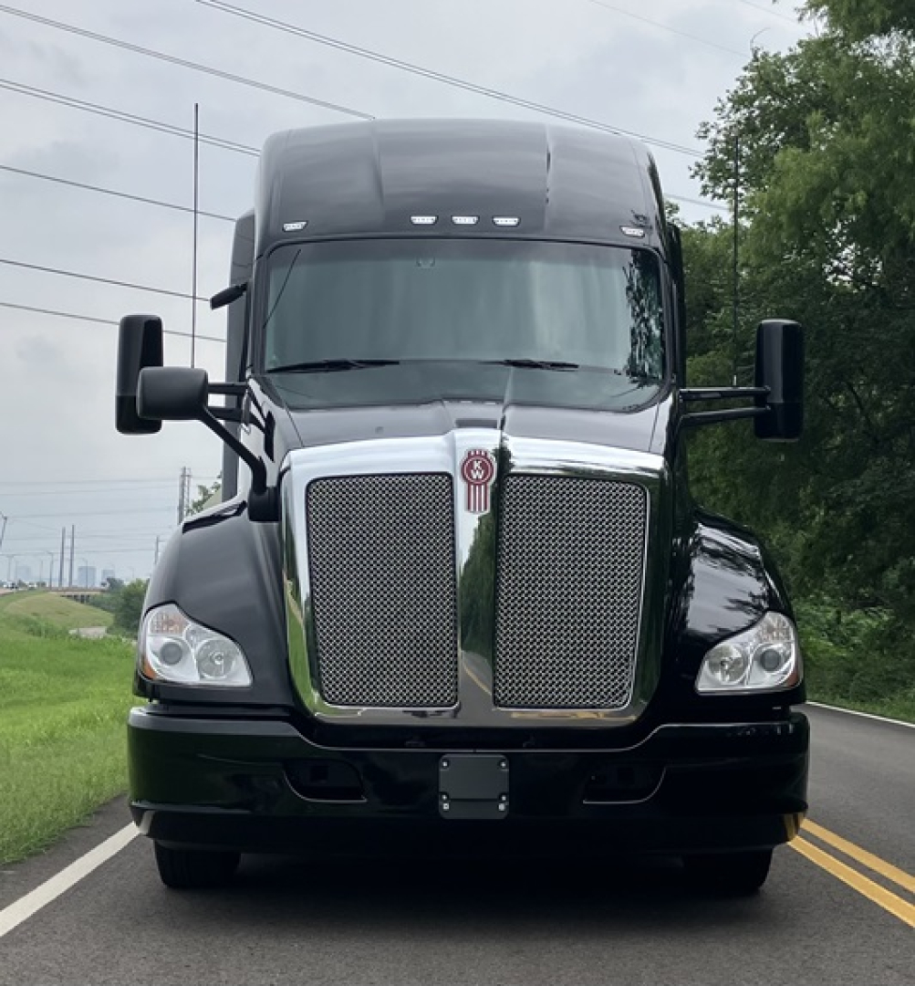 Kenworth T680 front view showing chrome grille, large hood, and dual mirrors.
