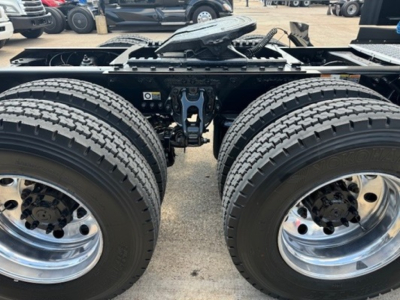 Kenworth T680 chassis with dual rear axles showing tires, rims, and frame showing suspension components.