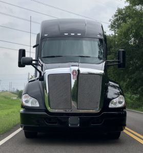 Kenworth T680 front view showing chrome grille, large hood, and dual mirrors.