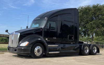 Kenworth T680 tractor-trailer in black, side view showing sleeper cab and rear wheels.