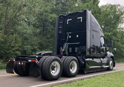Kenworth T680 truck tractor rear and side view showing fuel tanks and dual rear axles with fifth wheel area.