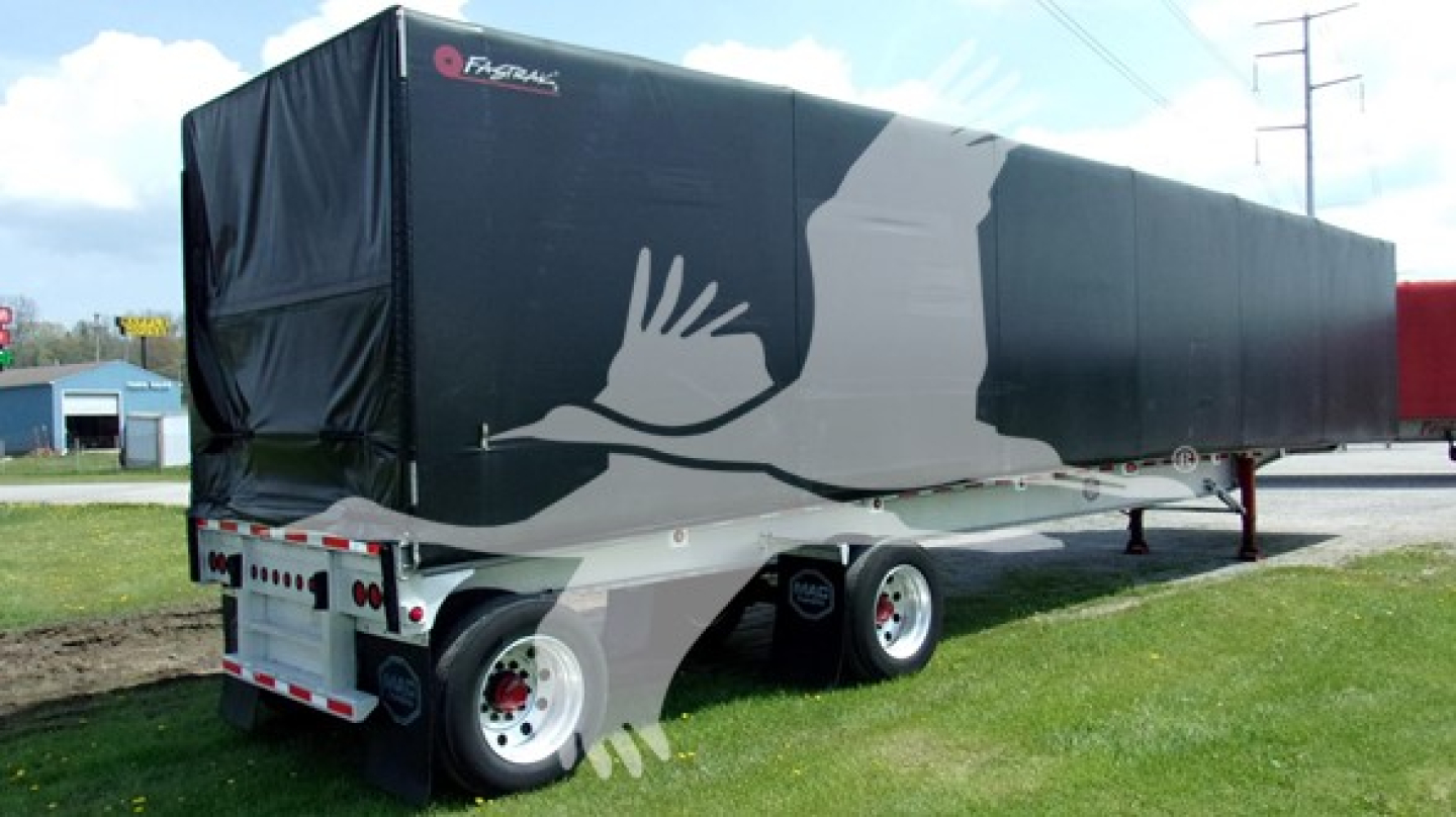 Trailer showing a Curtinside curtain side trailer with black tarp and white graphic, dual rear axles, side view.