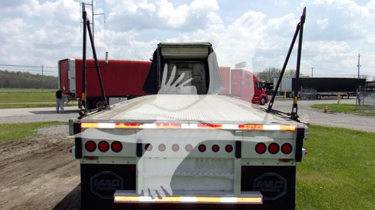 Rear view of a curtain-side trailer with MAC branding on mud flaps and rear bumper, showing multiple red tail lights and reflective strips.