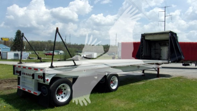 Curtainside trailer with open rear and raised tarp showing trailer deck and wheels. No legible text visible on labels in image.