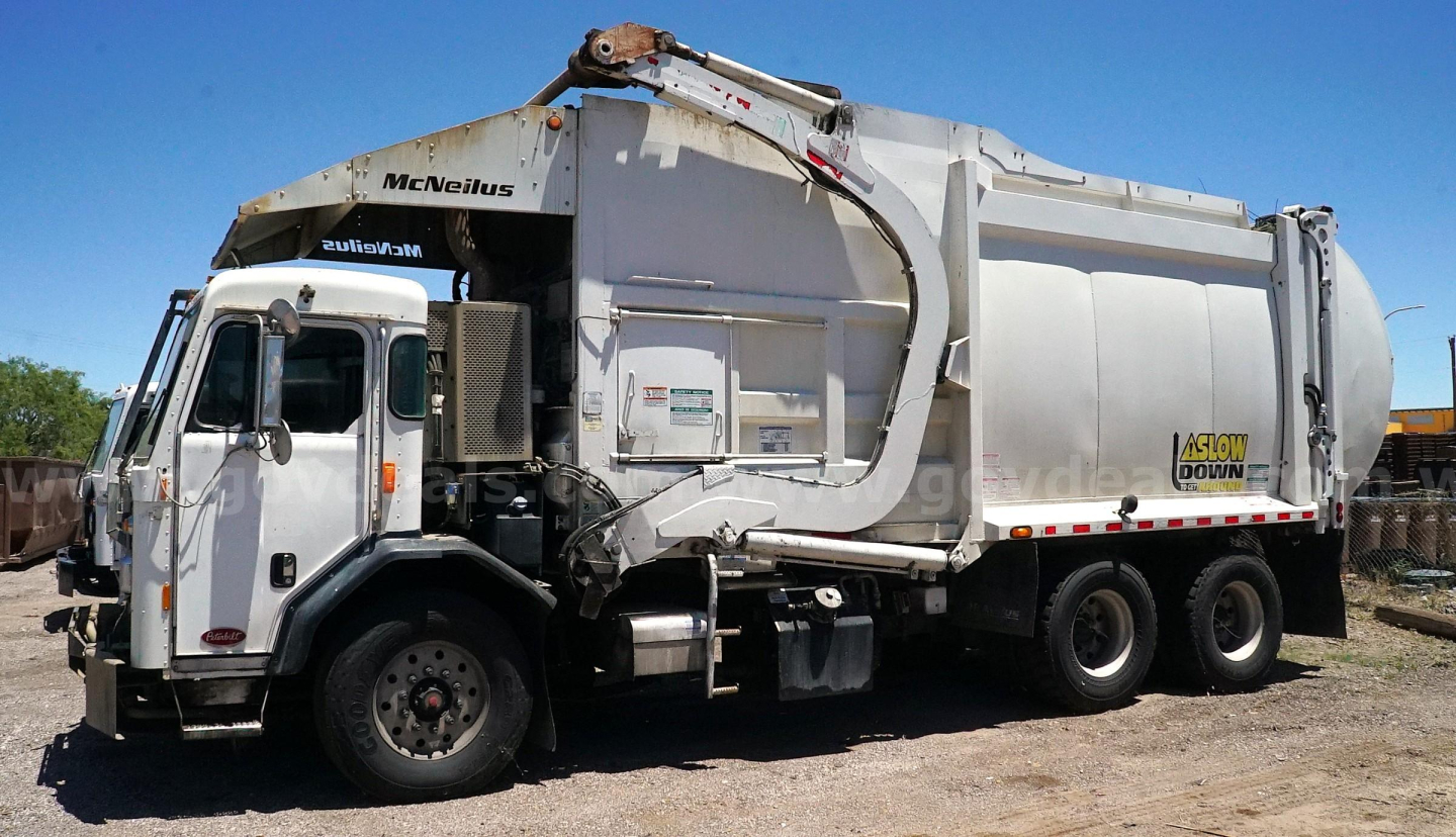 Garbage truck side view showing Mack/menens? style cab and rear compactor with hydraulic arm. Visible text includes 'MBeanius' on cab and 'GLOW' on side.