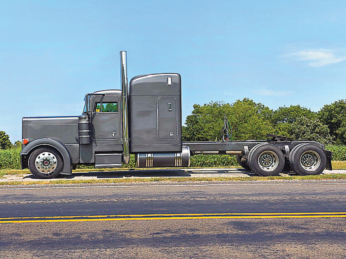 Peterbilt 379 UltraCab extended hood truck side view with sleeper cab and 3-axle chassis.