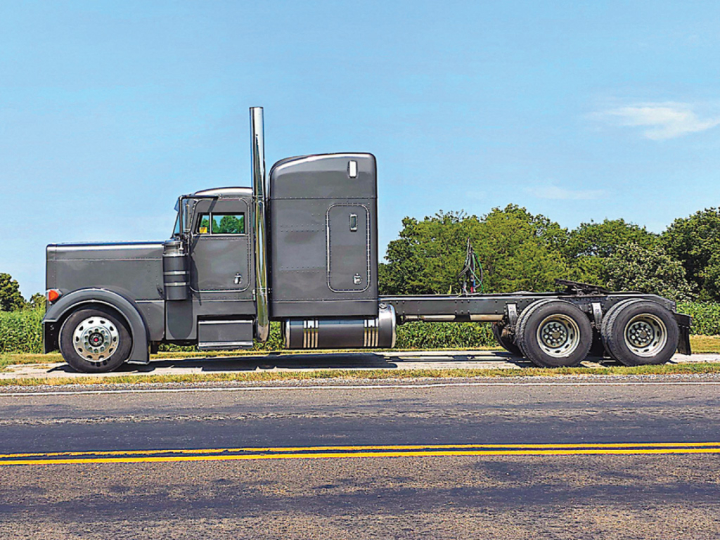 Peterbilt 379 UltraCab extended hood truck side view with sleeper cab and 3-axle chassis.