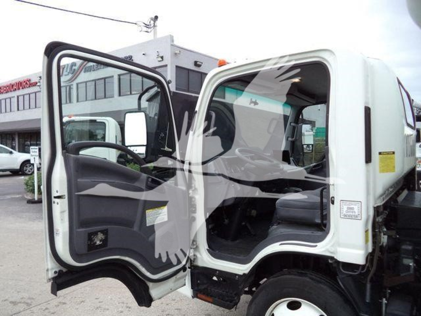 Isuzu NPR (2019) box truck with cab doors open showing interior seating and steering wheel.