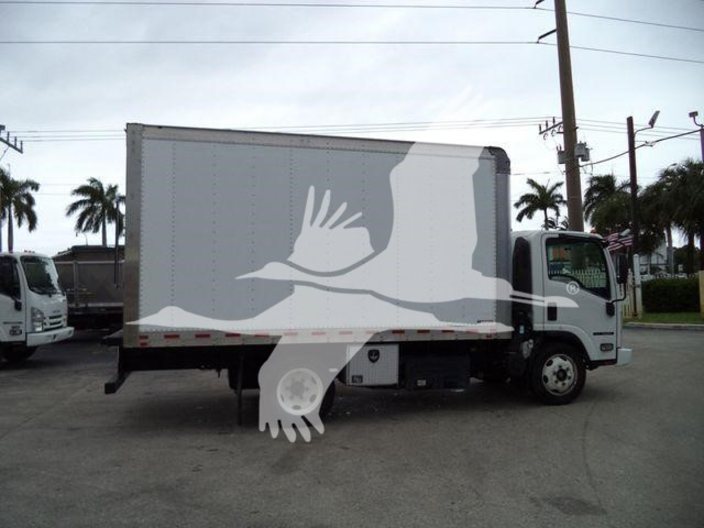 Isuzu box truck side view showing cargo box and cab with white silhouette watermark across