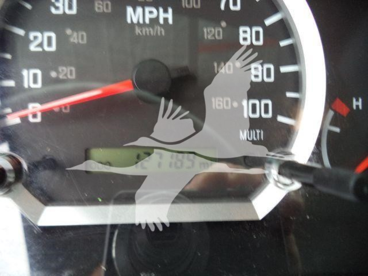 Isuzu truck dashboard showing speedometer with mph and km/h scales; partial odometer display and gauge housings visible.