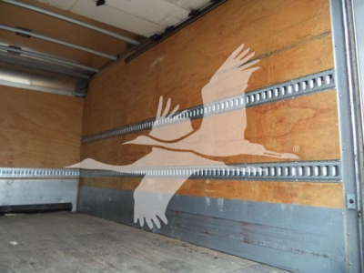 Isuzu box truck cargo area with wooden walls and metal E-track rails, no cargo, side panel with bird graphic visible.