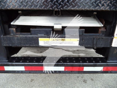 Isuzu NQR truck rear view showing lowered tailgate step and warning label on bumper.
