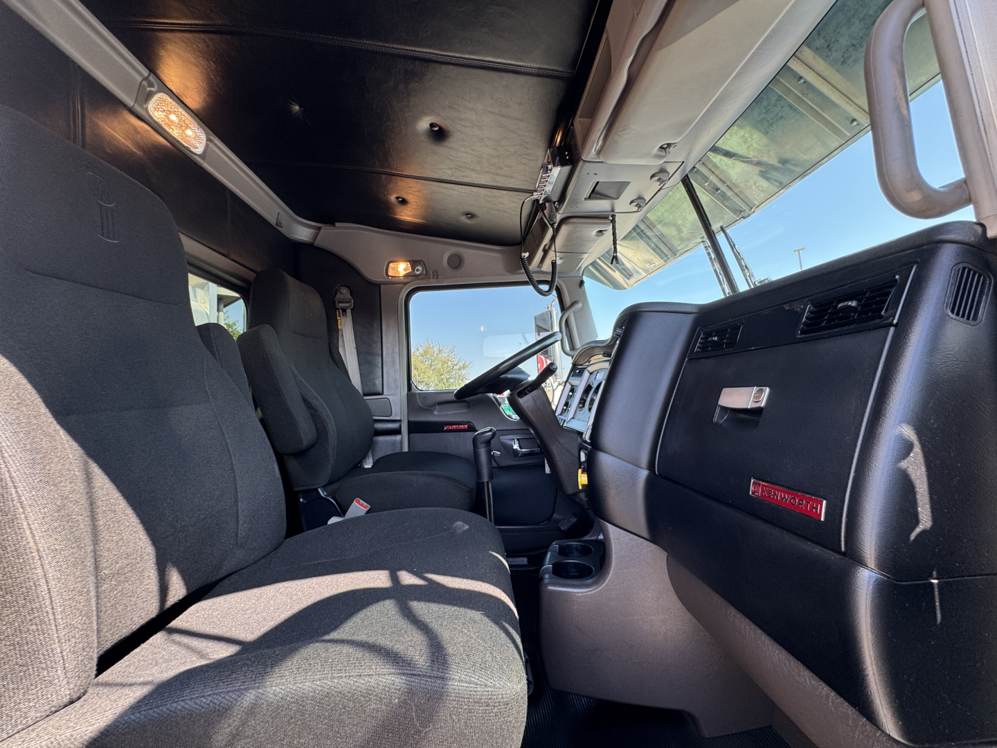 Kenworth W900L truck interior showing dashboard and front seats with steering wheel and controls