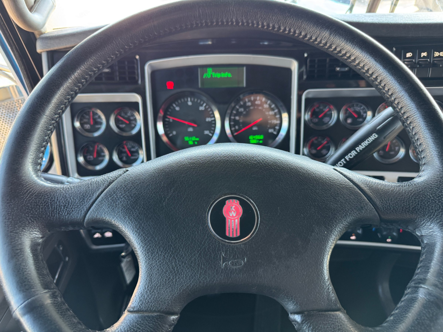 Kenworth W900L interior dashboard and steering wheel with multiple gauges and steering column switch visible