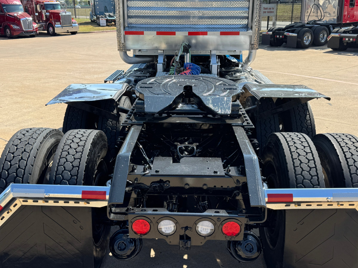 Rear view of a Kenworth W900L tractor chassis showing dual rear axles, suspension, and chassis components.