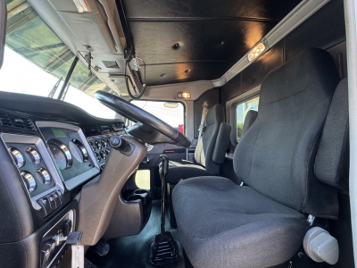 Kenworth W900L truck cabin interior showing steering wheel, dashboard gauges, and driver seat.