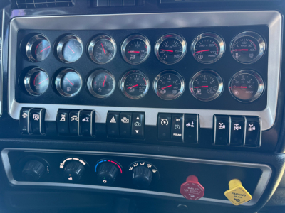 Gauges and controls on Kenworth W900L dash showing multiple round instruments.