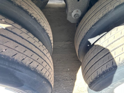 Two rear trailer axles with large tires, undercarriage components visible between wheels in a Utility 4000DX TBR trailer.
