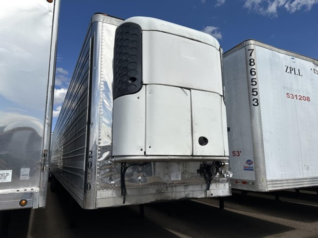 Reefer trailer in a yard showing front refrigeration unit and door hinges, with other trailers nearby; 53' length markings visible and cooling unit on the nose.