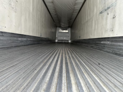 Trailer interior showing ribbed metal floor and side walls of a 2009 Utility 3000r trailer, long perspective toward rear opening.