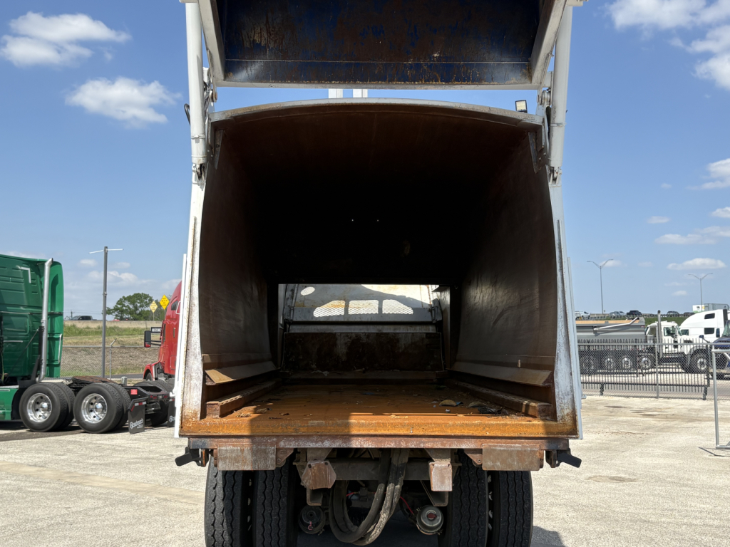 Truck dump bed interior of a 2019 Autocar XPEDITOR showing cargo area with wooden floor and metal sides, open tailgate.