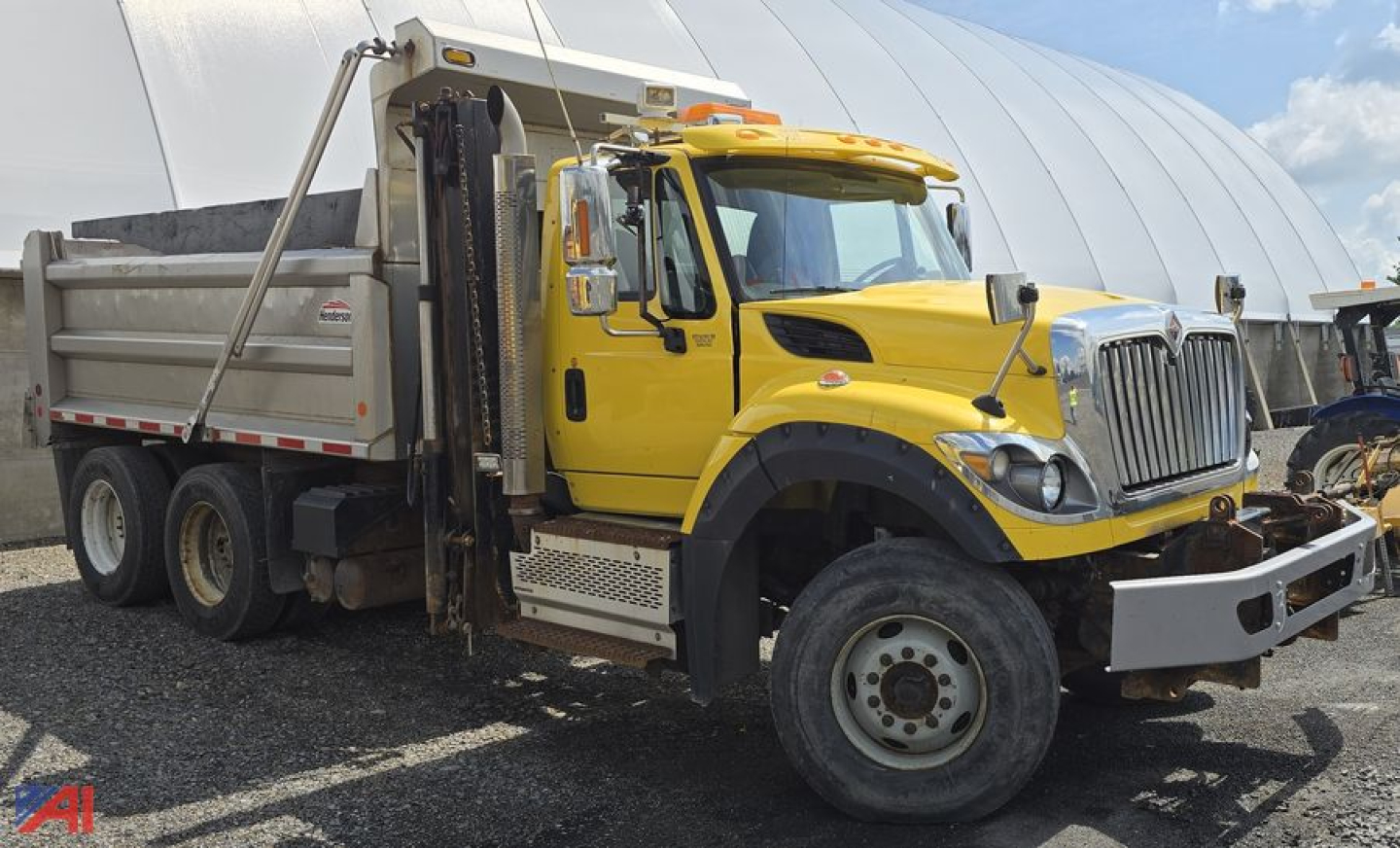 Dump truck: 2016 International WorkStar 7600 with yellow cab, dump bed, and side steps. Front grille and headlights visible.