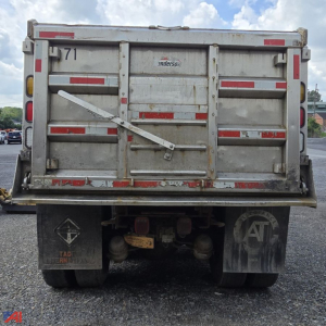 Dump truck tailgate with Anderson branding showing wear, rear lights, anti-splash mud flaps, and hydraulic dumps cables visible.