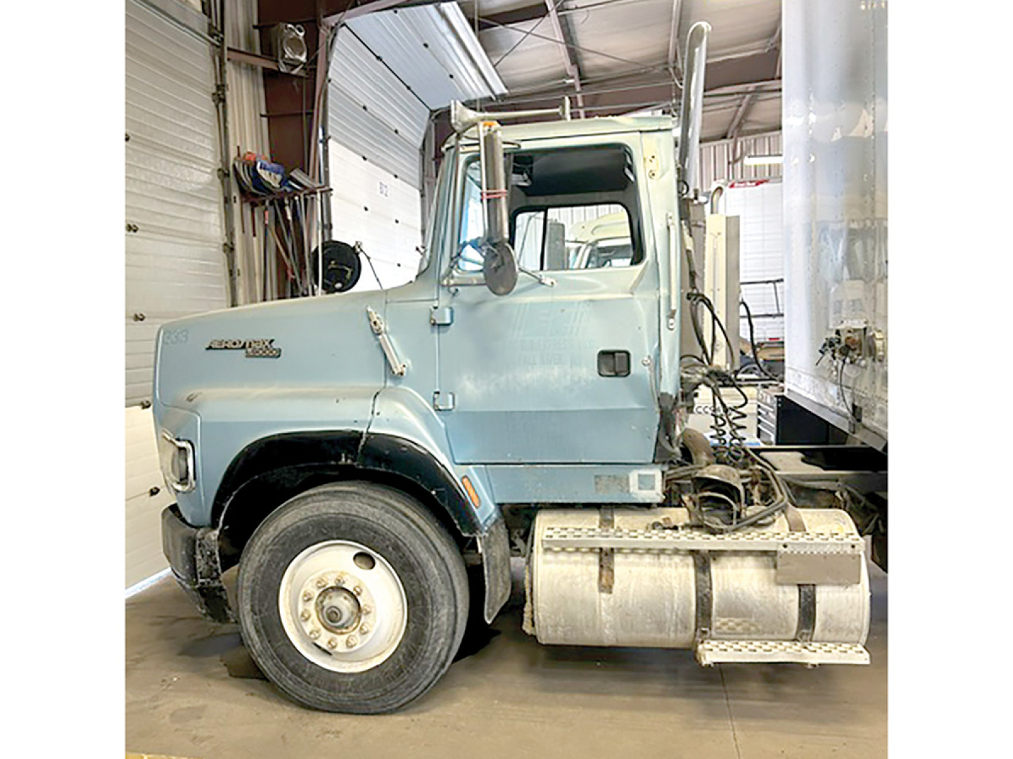 Ford L9000 AeroMax cab-over engine bay side view showing front wheel and fuel tank