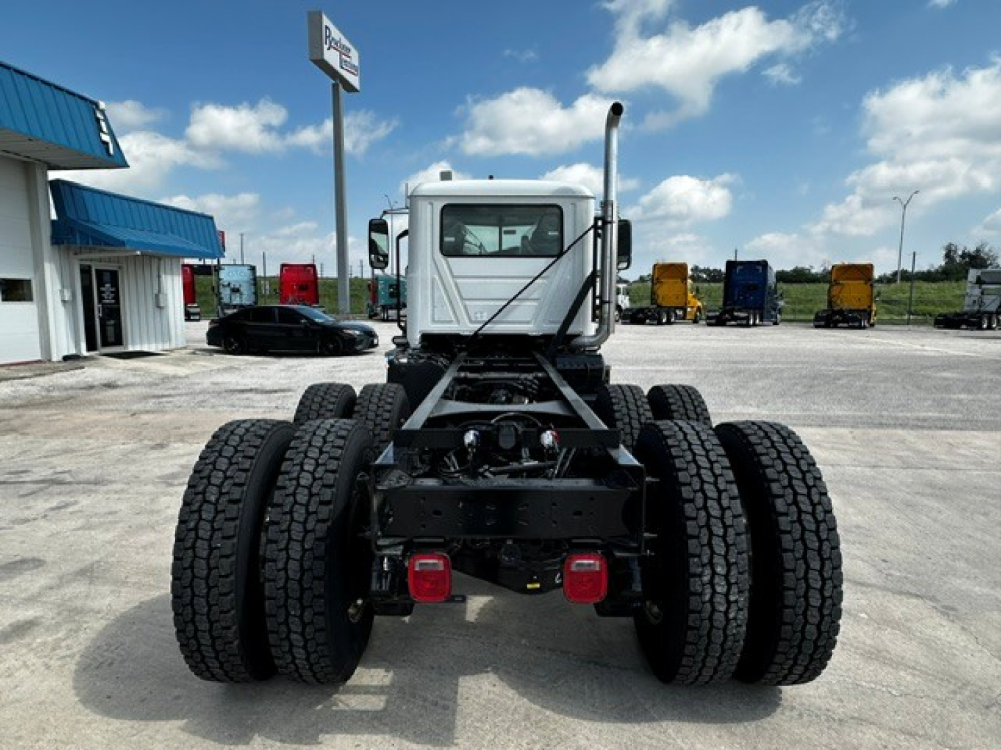 Rear view of a new 2027 Mack GR64F cab and chassis showing dual rear axle configuration and chassis frame.