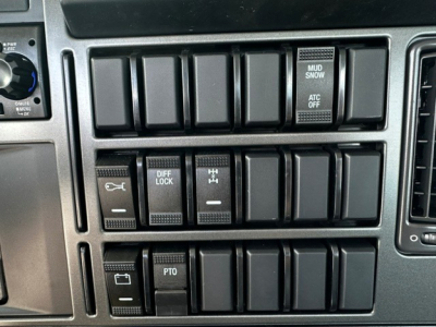 Dashboard switch panel showing multiple rocker switches and labels, including DIFF LOCK, PTO, MUD/ SNOW, ATC OFF, and other blank slots.