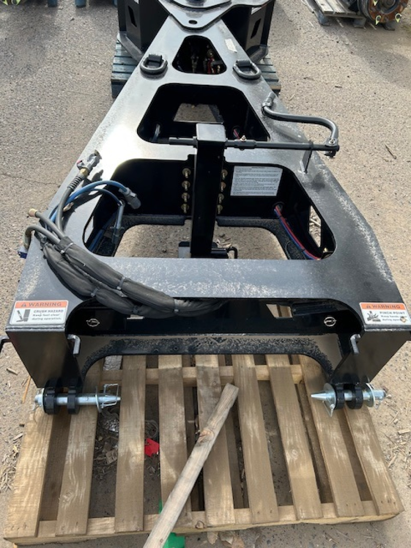 Lowboy trailer frame showing hydraulic hoses, mounting points, and support cross member for a 55 ton Alpha ASB1 spreader bar with wooden ramp on pallet.