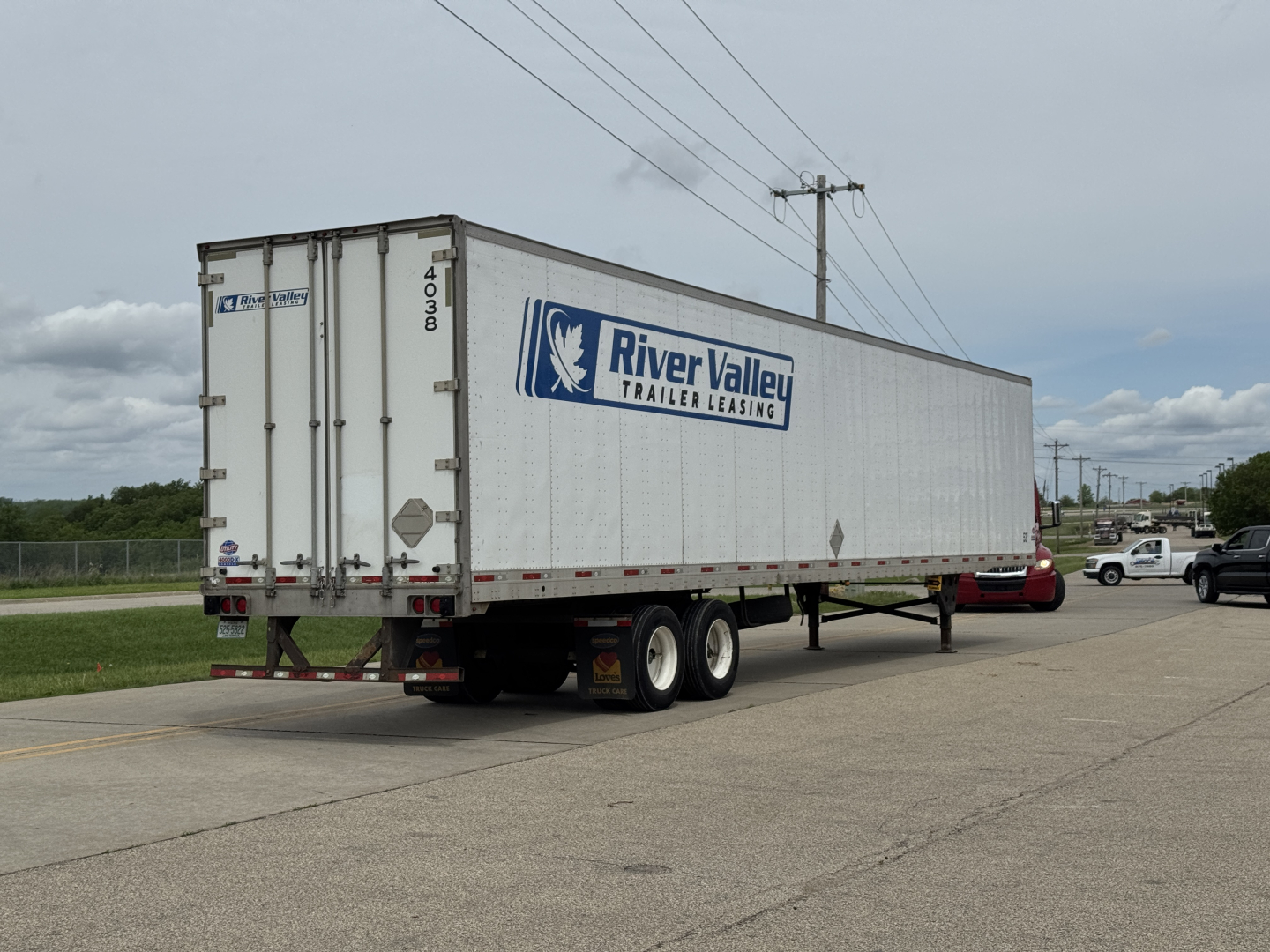 Trailer side view showing River Valley Trailer Leasing logo on a white dry van trailer with wheels and rear doors.