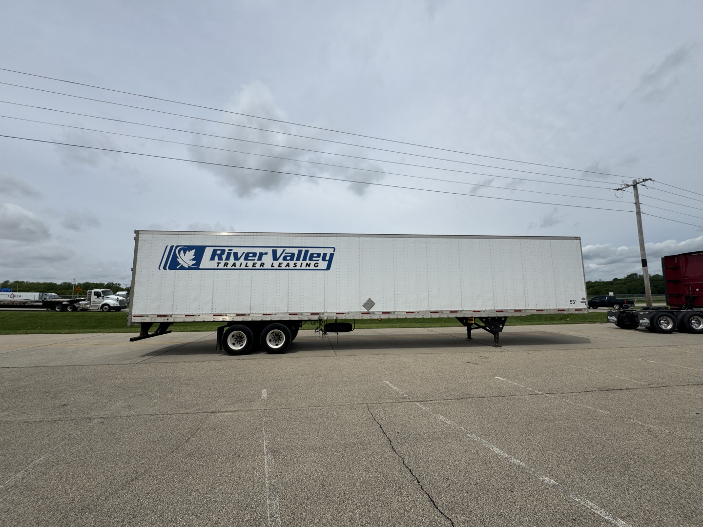 Trailer body showing River Valley trailer leasing logo on the side of a large white utility trailer.