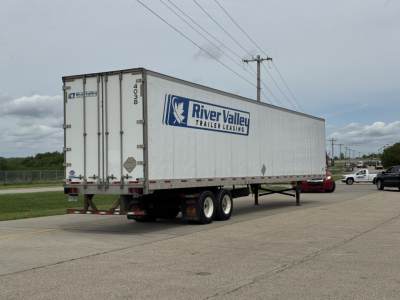 Trailer side view showing River Valley Trailer Leasing logo on a white dry van trailer with wheels and rear doors.