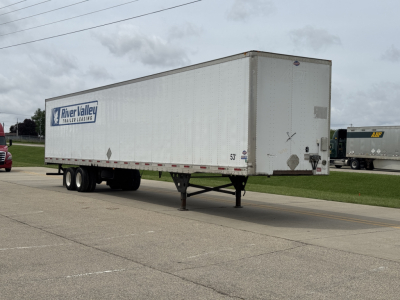Trailer viewed from side with River Valley trailer lease logo, utility 4000 Dx trailer on parked road, front landing gear and wheels visible.