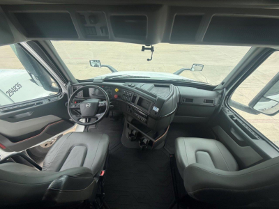 Volvo VNR cabin dashboard and seats from driver perspective showing steering wheel and console