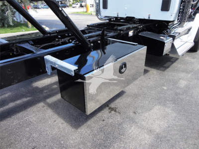 Kenworth W990 rollback chassis with glossy black tool/storage toolbox attached under the cab.