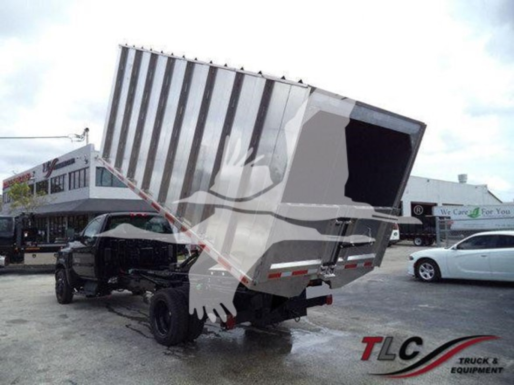 Truck chassis with mid-dump dump bed raised showing cargo bed and hydraulic components.