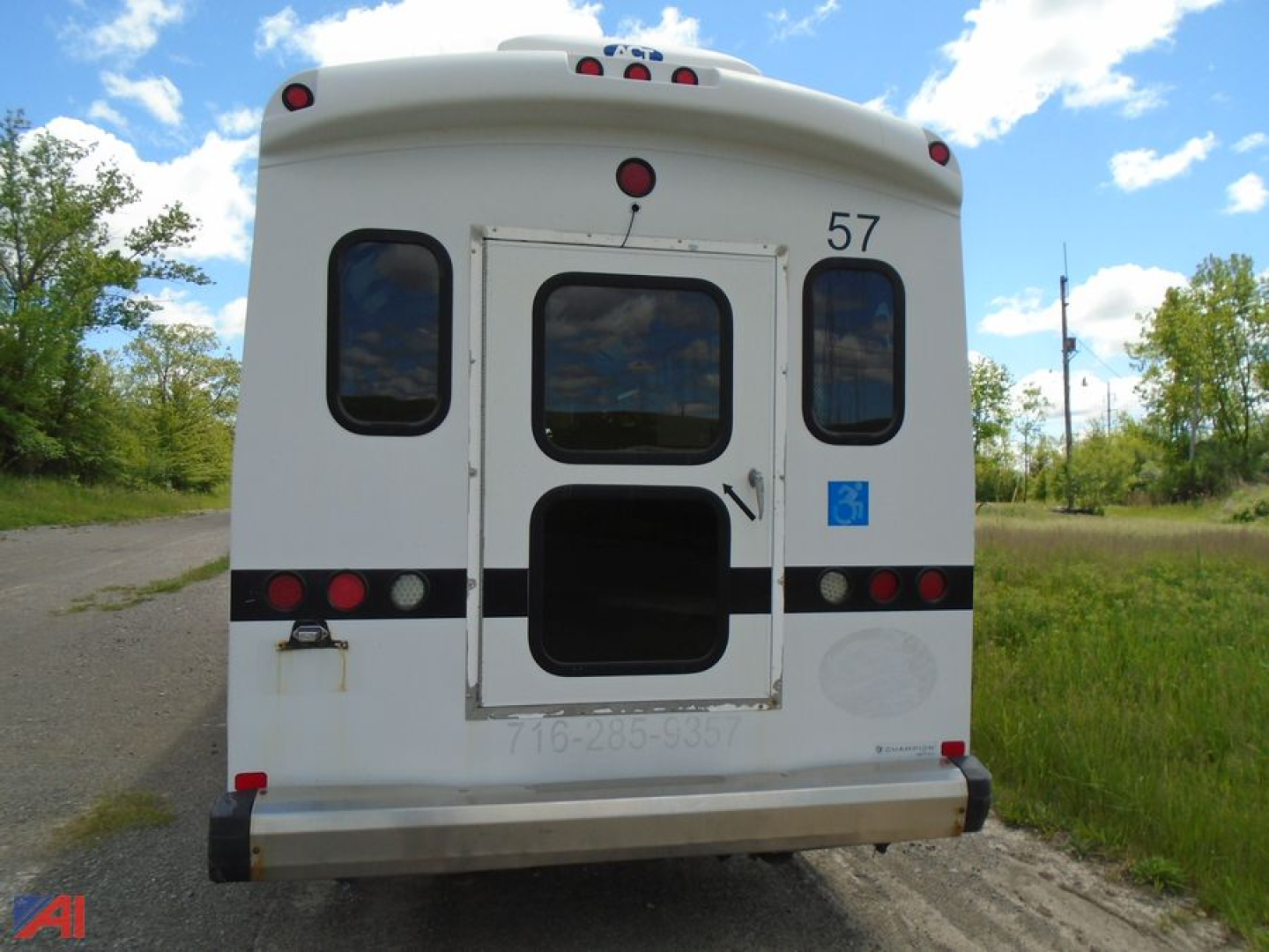 Freightliner S2 bus rear showing door, numbered 57, rear window, lights, and blue accessibility placard.