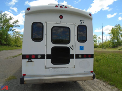 Freightliner S2 bus rear showing door, numbered 57, rear window, lights, and blue accessibility placard.