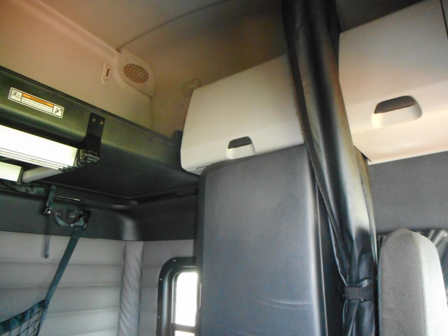 Freightliner Cascadia cab interior showing overhead bunk area and storage compartments