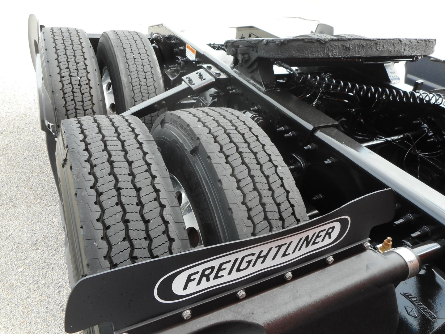Freightliner Cascadia tractor rear chassis showing dual rear wheels and Freightliner mudflap logo.