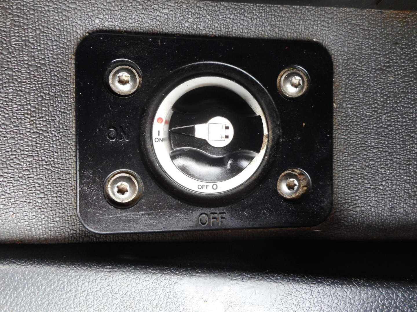 Dashboard switch panel with circular ignition-like knob showing ON/OFF markings in a Freightliner Cascadia interior image.